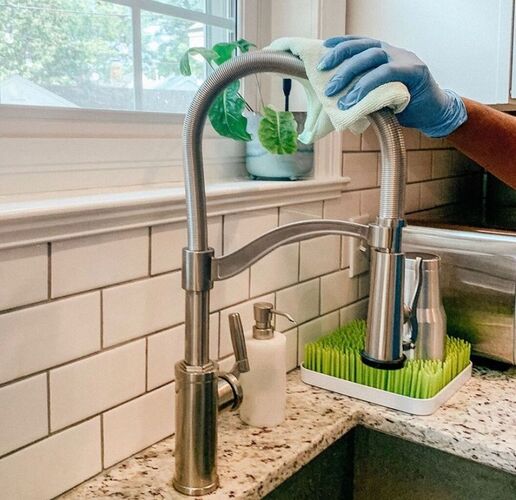 Merry Maids professional cleaning a faucet during house cleaning service
